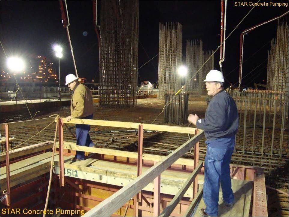 Cuadrilla de S.T.A.R. colocando concreto bajo las luces, de noche